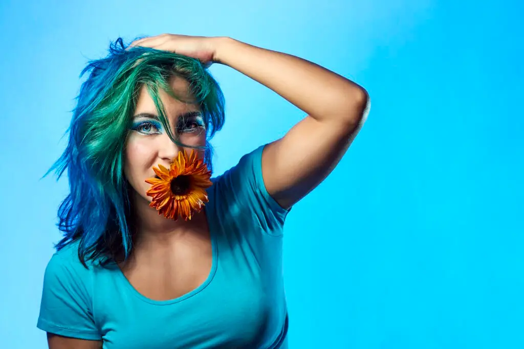 close-up-of-a-young-woman-with-a-flower-on-a-blue-John-FRANCEY