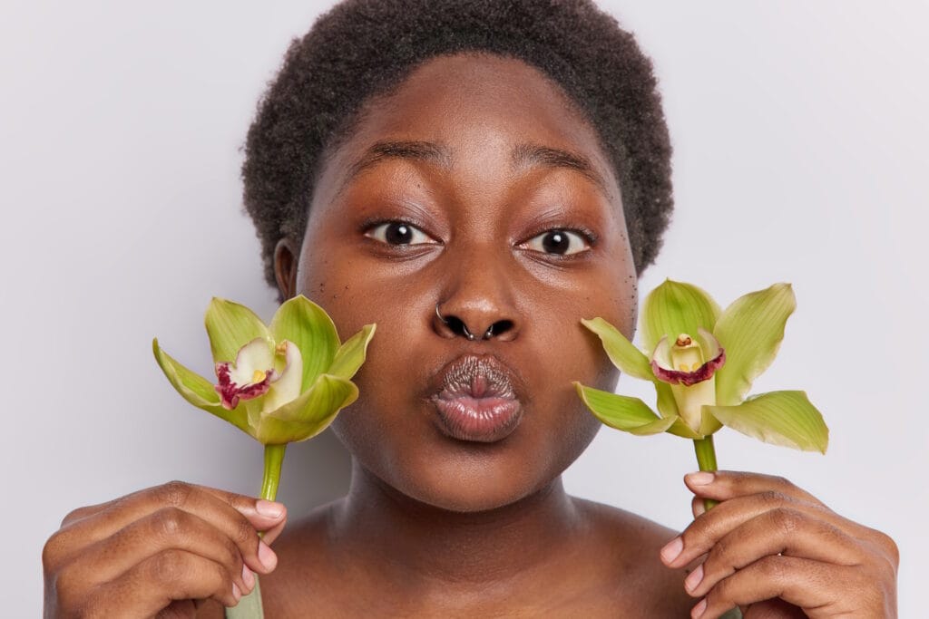 Headshot of naturally beautiful dark skinned young woman flowers John FRANCEY