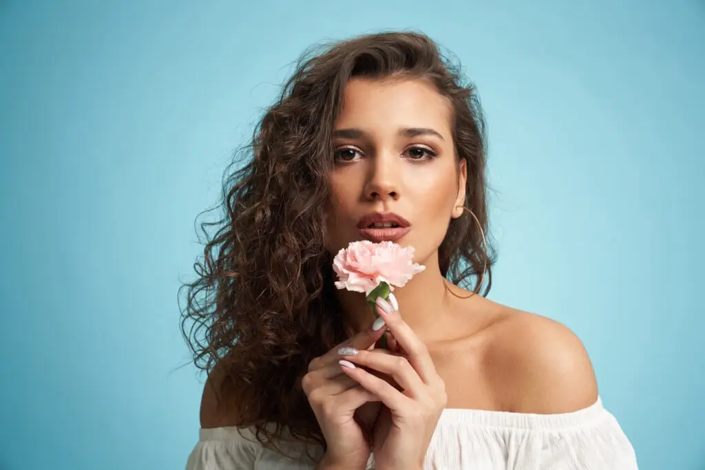 pretty-woman-with-flower-isolated-on-blue-John-FRANCEY